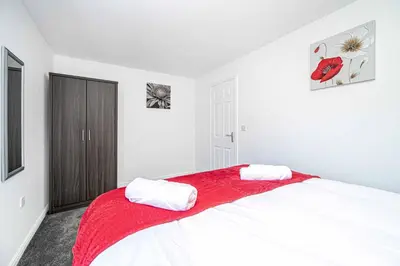 a bedroom with a large bed with a red blanket at Super Prime Luxury 4 Bedroom Detached Home by TBA in Fife