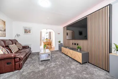 a living room with a couch and a large television at Super Prime Luxury 4 Bedroom Detached Home by TBA in Fife
