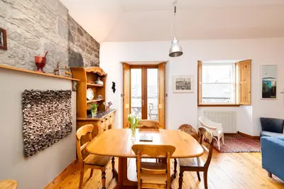 a living room with a wooden table and chairs at Edinburgh New Town Deluxe Apartment with Terrace in Edinburgh