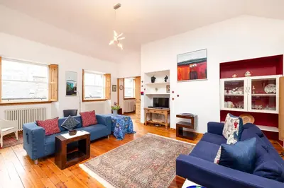 a living room with blue couches and a table at Edinburgh New Town Deluxe Apartment with Terrace in Edinburgh
