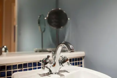 a bathroom sink with a faucet and a mirror at Bright & Stylish West End Apartment in Edinburgh