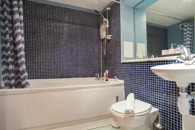 a bathroom with a toilet and a tub and a sink at Bright & Stylish West End Apartment in Edinburgh