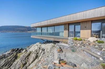 a house on a cliff next to the water at 4 Bed in Cove oc-r31840 in Cove