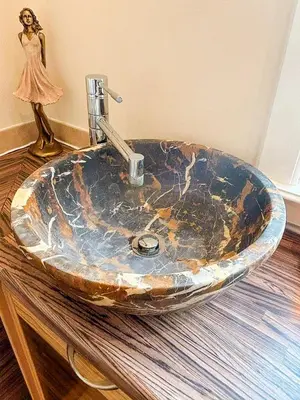 a bathroom sink with a statue of a woman next to it at The Old High Road, North Ayrshire in Stevenston