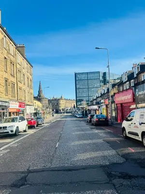 an empty city street with cars parked on it at Haymarket Centro , Flat familiar quarto privativo banheiro compartilhado in Edinburgh