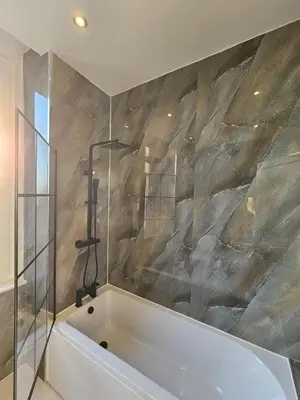 a bath tub in a bathroom with a stone wall at Central Hotel Edinburgh in Edinburgh