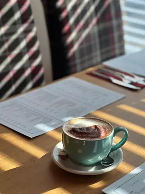 a cup of coffee sitting on a wooden table at The Cornhill Inn in Falkirk