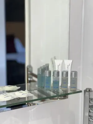 a glass shelf with four bottles of moisturizers on it at The Cornhill Inn in Falkirk