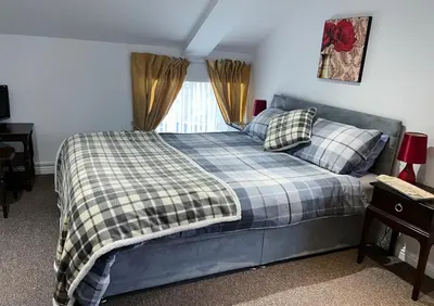 a bedroom with a bed with a checkered blanket at 3 Telford Mews in Dumfries