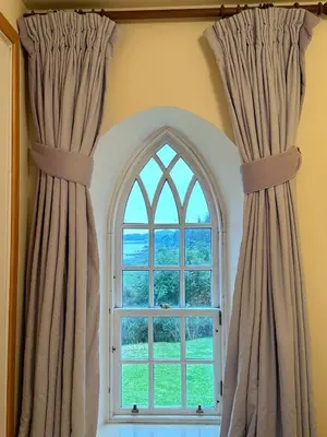 an arched window with curtains in a room at Leargy House in Isle of Jura