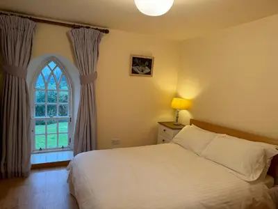 a bedroom with a white bed and a window at Leargy House in Isle of Jura