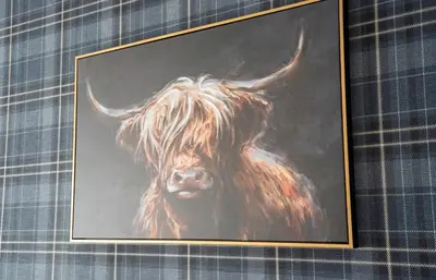 a painting of a cow in a frame on a wall at The Rise Retreat in Livingston