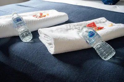 two bottles of water and towels on a bed at The Rise Retreat in Livingston