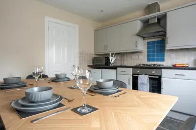 a kitchen with a wooden table with wine glasses on it at The Rise Retreat in Livingston
