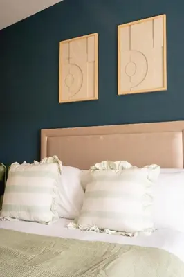 a bedroom with a bed with two pictures on the wall at Marina House in Bathgate