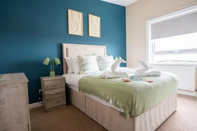 a bedroom with a bed with two stuffed animals on it at Marina House in Bathgate
