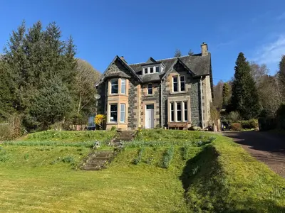 an old stone house on a grassy hill at Crannaig House in Aberfoyle