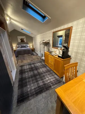 a room with a bedroom with a bed and a mirror at Crannaig House in Aberfoyle