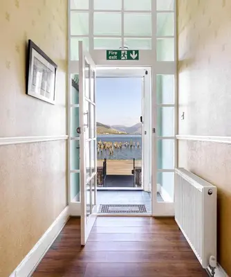 a door leading into a room with a view of a beach at Ardyne House in Port Bannatyne