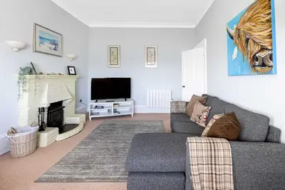a living room with a couch and a television at Coastal Charm in Kingarth