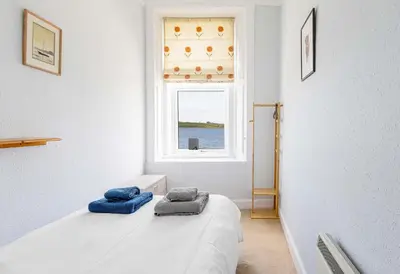a bedroom with a bed with blue towels on it at Coastal Charm in Kingarth