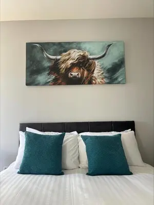 a painting of a cow with horns on a bed at Glenroy Guest House in Oban