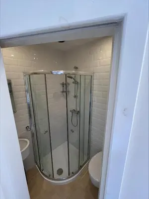 a glass shower in a bathroom with a toilet at Glenroy Guest House in Oban