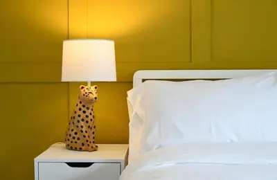 a lamp on a night stand next to a bed at Homely 2 Bed House with Private double driveway in Oban