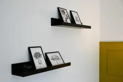 a shelf on a wall with three pictures on it at Homely 2 Bed House with Private double driveway in Oban