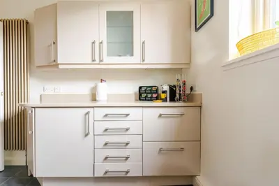 a kitchen with white cabinets and a sink at Amulree, Edinburgh City in EDI