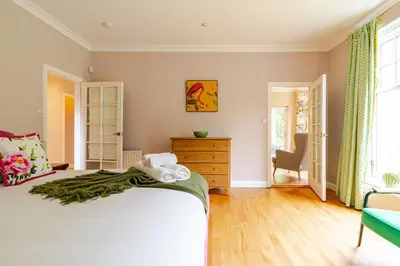a bedroom with a large bed and a dresser at Amulree, Edinburgh City in EDI