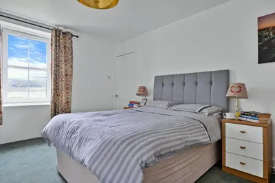 a bedroom with a large bed and a window at Finest Retreats - Lochead Cottage in Achahoish