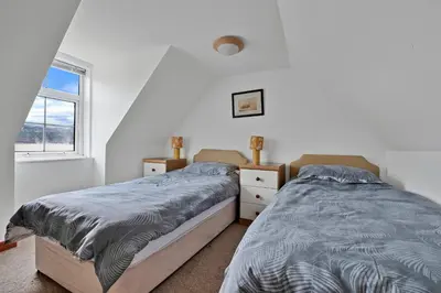 a bedroom with two beds and a window at Finest Retreats - Lochead Cottage in Achahoish