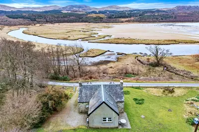 an aerial view of an old house next to a river at Finest Retreats - Lochead Cottage in Achahoish