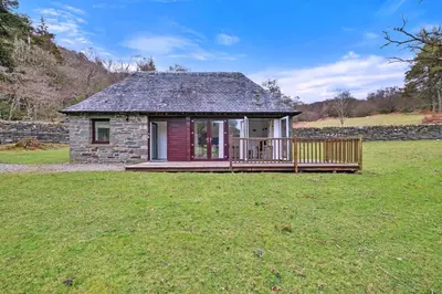 a small house with a deck in a field at Finest Retreats - The Turbine House in Achahoish