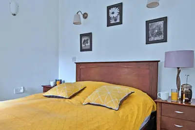 a bedroom with a yellow bed with two pillows at Finest Retreats - The Turbine House in Achahoish