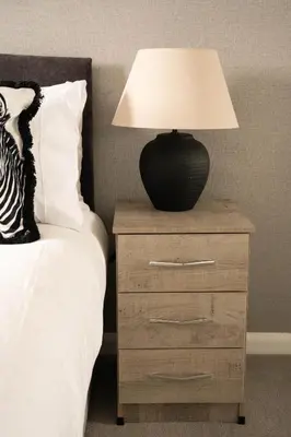 a lamp on a night stand next to a bed at Stirling Street Stays in Tillicoultry