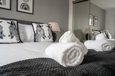 a bedroom with a bed with towels on it at Stirling Street Stays in Tillicoultry