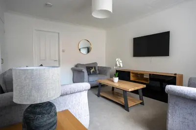 a living room with a couch and a tv at Stirling Street Stays in Tillicoultry