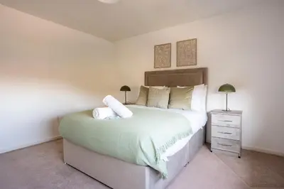 a bedroom with a large bed and a night stand at Carradale House in Falkirk