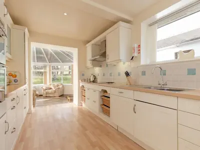 a kitchen with white cabinets and a large window at Holiday Home Balcraig House by Interhome in Straiton
