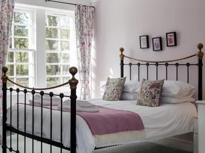a bedroom with a black bed with pillows at Holiday Home Balcraig House by Interhome in Straiton