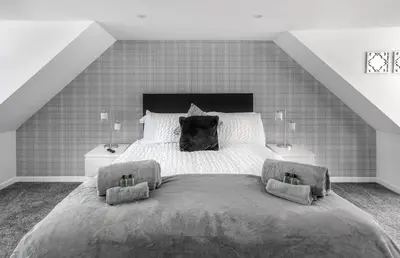 a bedroom with a large bed with two night stands at Castle Street Apartments - Luxury Kilchattan Apartment in Rothesay