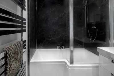 a shower with a faucet in a bathroom at Castle Street Apartments - Luxury Scalpsie Apartment in Rothesay