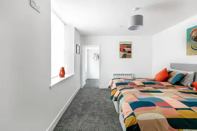 a bedroom with a bed with a colorful quilt at Castle Street Apartments - Luxury Scalpsie Apartment in Rothesay