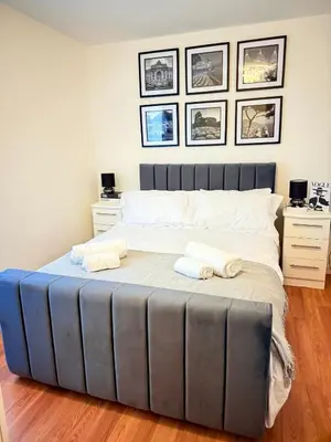 a bedroom with a large bed with two towels on it at 2 Bedroom Apartment near Glasgow City Centre, Celtic Park and Emirates Arena in Glasgow