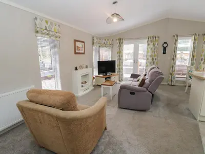 a living room with two chairs and a television at Lodge 2 in Auchterarder