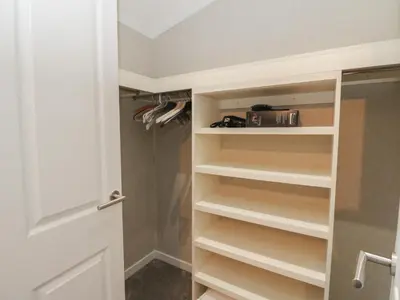 a closet with white shelves and a door at Lodge 2 in Auchterarder