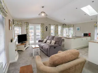 a living room with a couch and a kitchen at Lodge 2 in Auchterarder