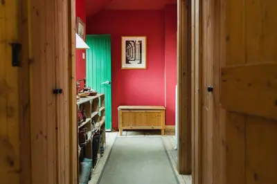 a hallway with a room with red walls and a table at B&B on Beautiful Organic Homestead, Edinburgh in Loanhead